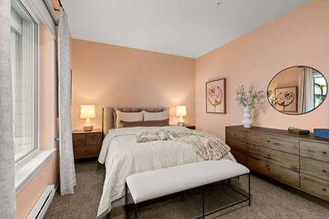 A bedroom with a bed, nightstands, and a mirror.