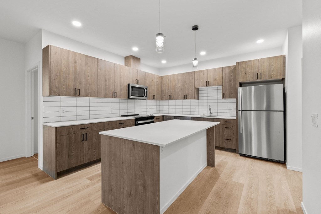 A modern kitchen with wooden cabinets and a white island.