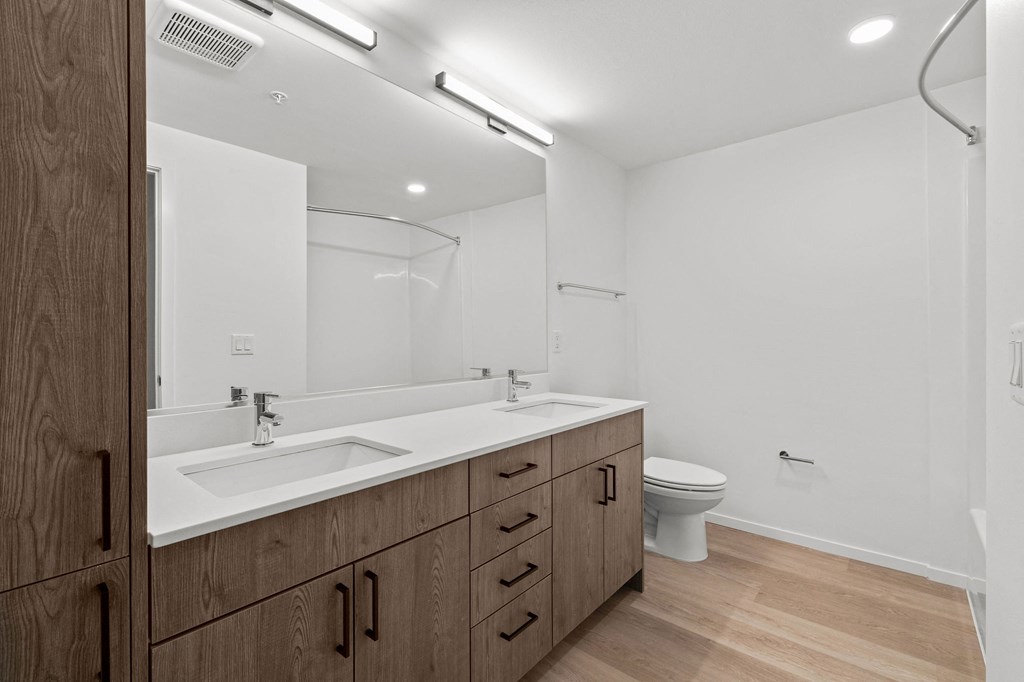 A bathroom with a white sink and a white toilet.