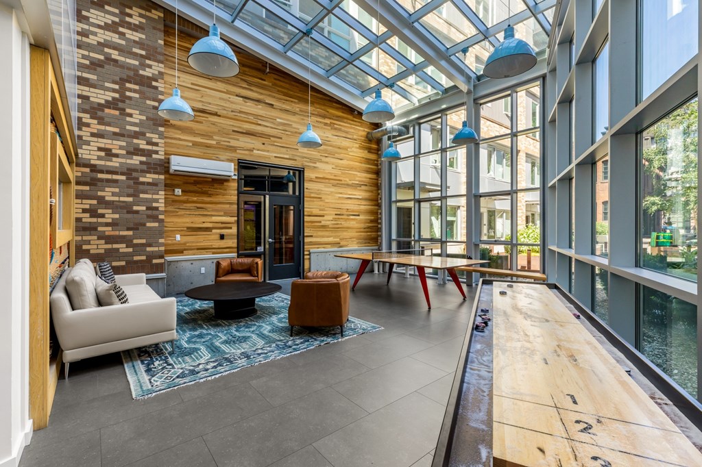 A modern living room with a glass ceiling and a wooden floor.