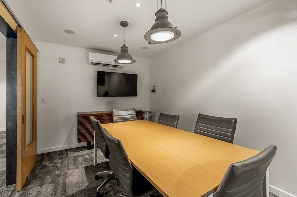 A conference room with a long table and chairs.