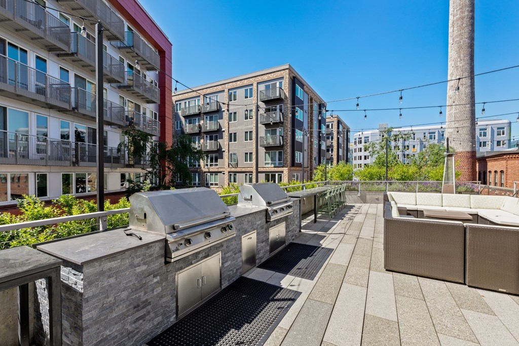A modern outdoor kitchen area with a grill and seating area.