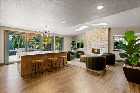 A modern living room with a stone fireplace and a bar area.