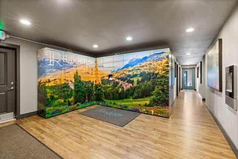 A hallway with a large mural of a forest scene on the wall.