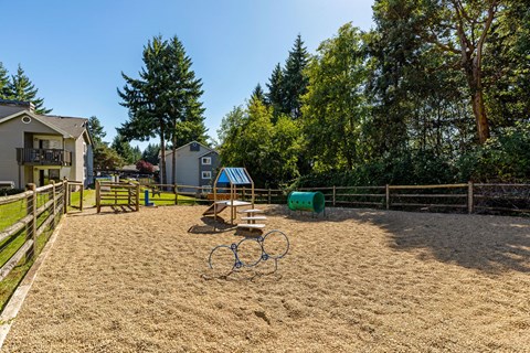 A playground with a swing set and sandbox in the foreground.