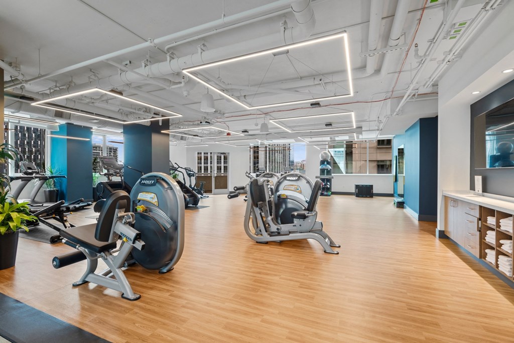a gym with cardio machines and weights on a wooden floor