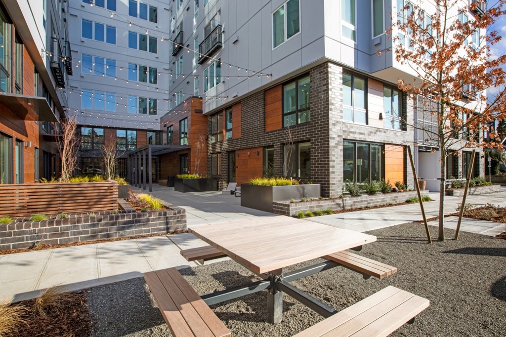 a picnic table in a courtyard in front of a building