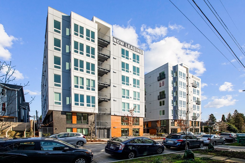 a group of apartment buildings with cars parked in front of them