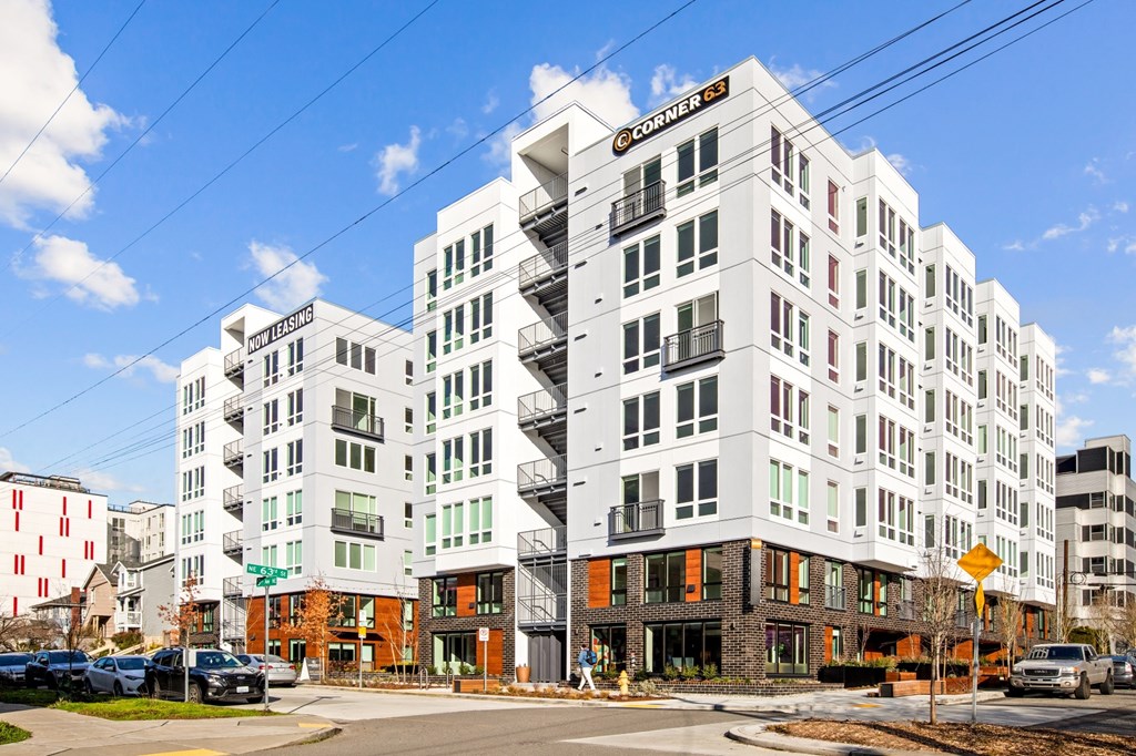 a rendering of a white apartment building on a city street