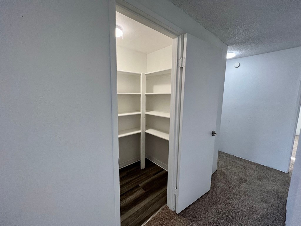 an empty closet with shelves in a small room