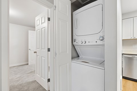 A white oven and microwave are built into a kitchen cabinet.