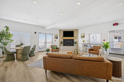 A living room with a brown sofa and green chairs.