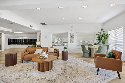 A living room with a brown sofa, a brown coffee table, and a green armchair.