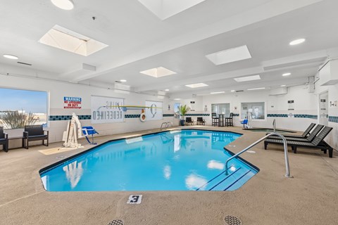 Indoor swimming pool with skylights and lounge chairs at The Q Apartments, Kennewick, WA 99336