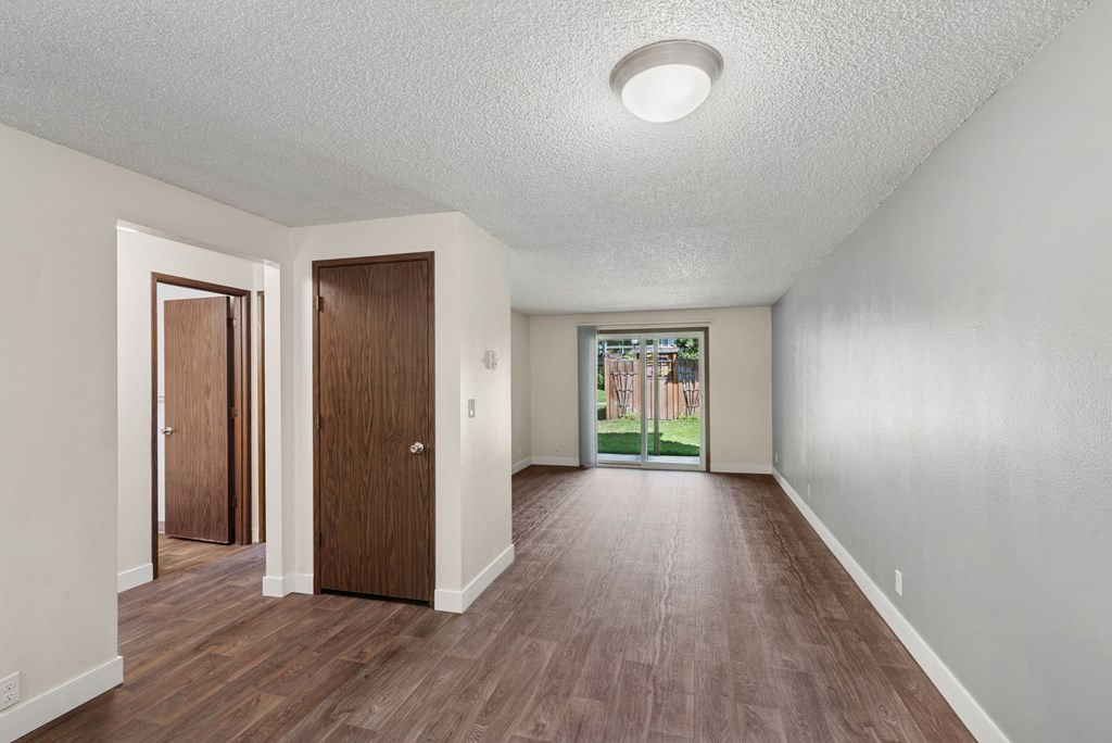 A room with wooden floors and two doors.