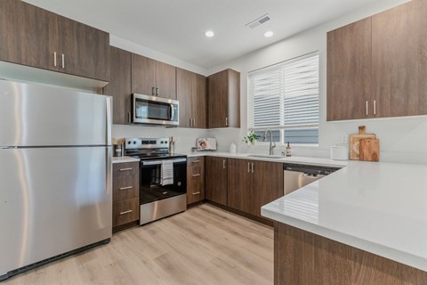 A modern kitchen with wooden cabinets and stainless steel appliances.