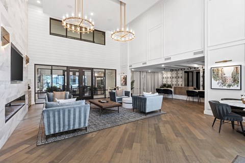 A modern living room with a grey sofa and wooden floors.