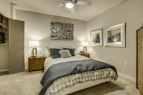 A bedroom with a large bed and a ceiling fan.