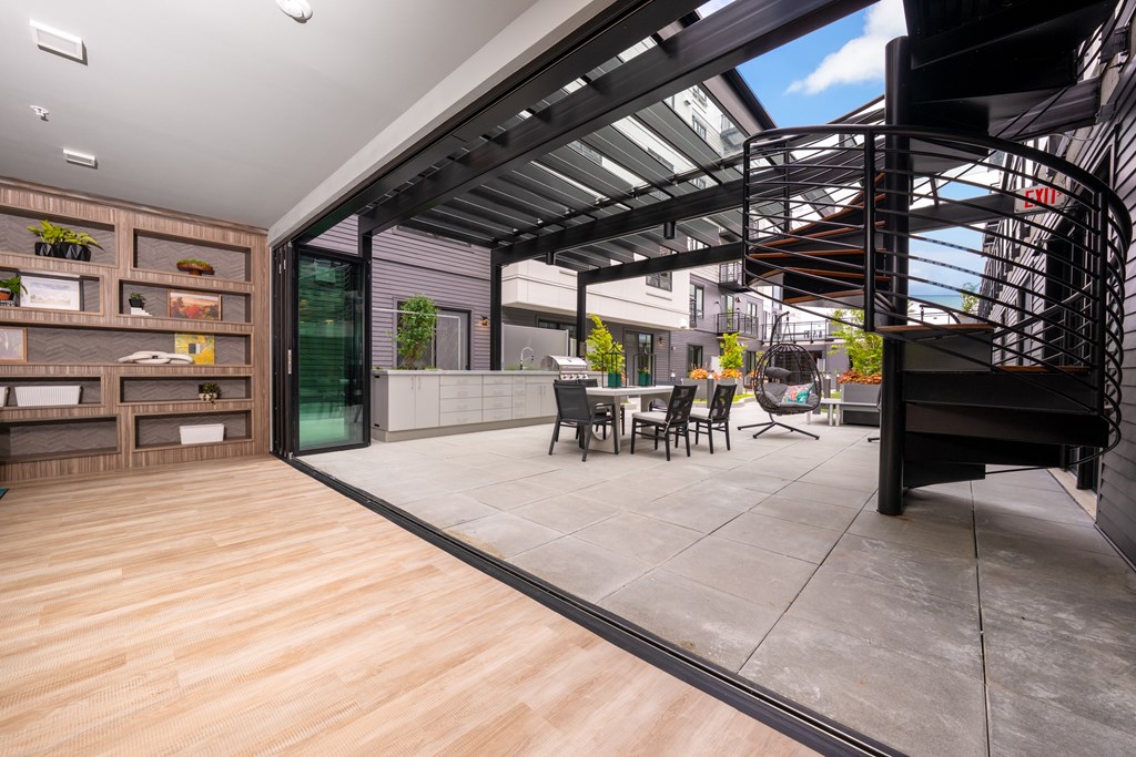 A modern patio with a wooden floor and a glass wall.