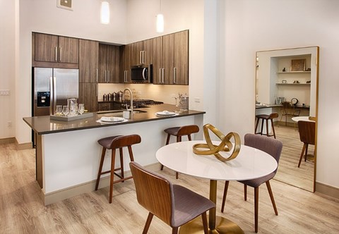 A modern kitchen with a dining table and chairs.