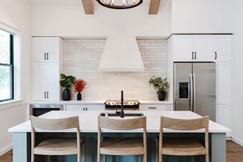 A kitchen with a white countertop and a white backsplash.
