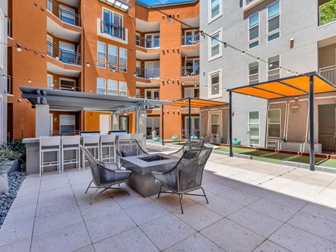 A patio with a table and chairs is in front of a building.