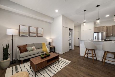 A modern living room with a wooden coffee table and a striped rug.