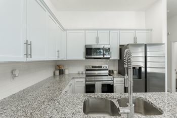 A kitchen with granite countertops and stainless steel appliances.