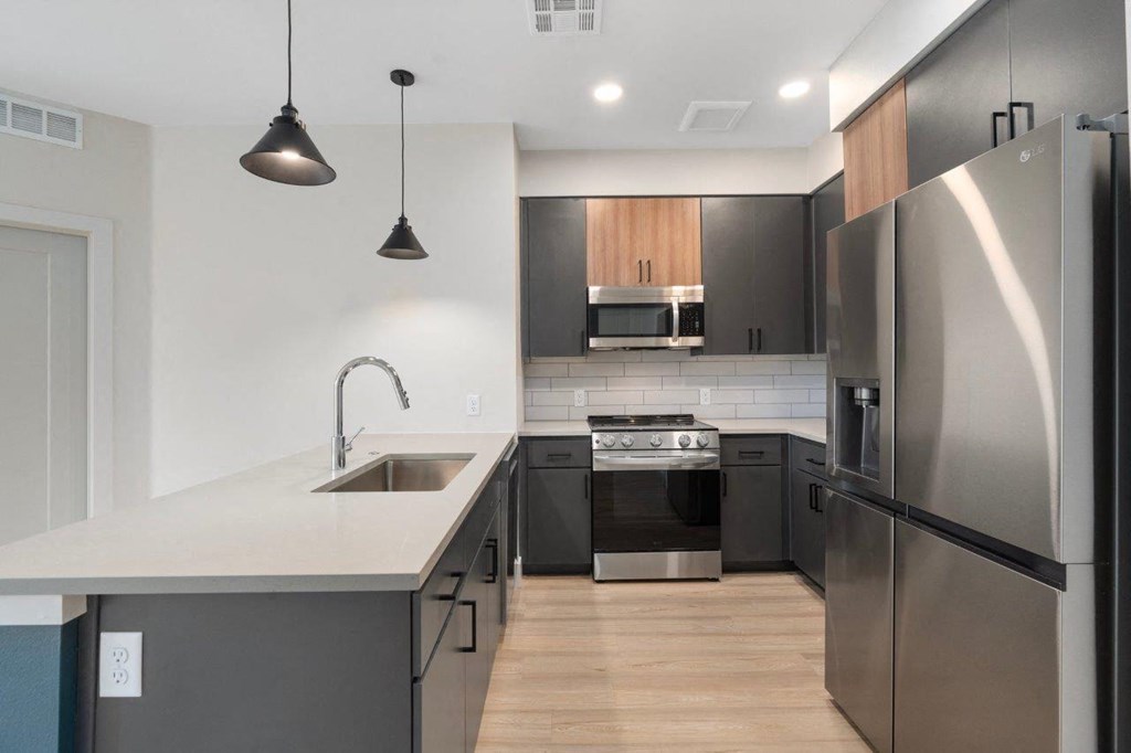 a renovated kitchen with a blue island and a stainless steel refrigerator