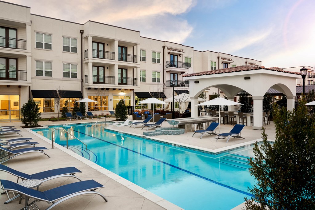 The Dylan  swimming pool with chaise lounge chairs and umbrellas in front of a building