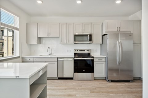 A modern kitchen with stainless steel appliances and white cabinets.