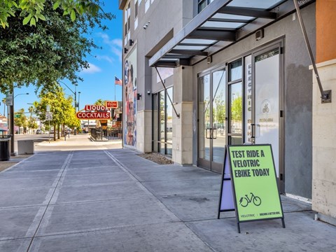 A sign on the sidewalk invites people to test ride a velotric ebike.