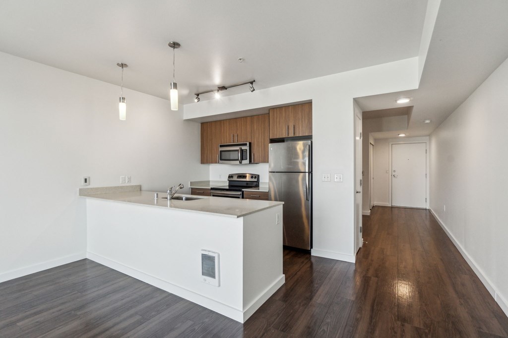 A kitchen with a white counter and a stainless steel refrigerator.
