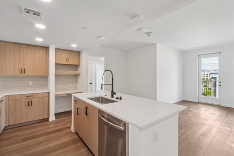 A modern kitchen with wooden cabinets and a stainless steel dishwasher.