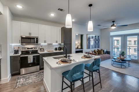 A modern kitchen with a dining table set for two.