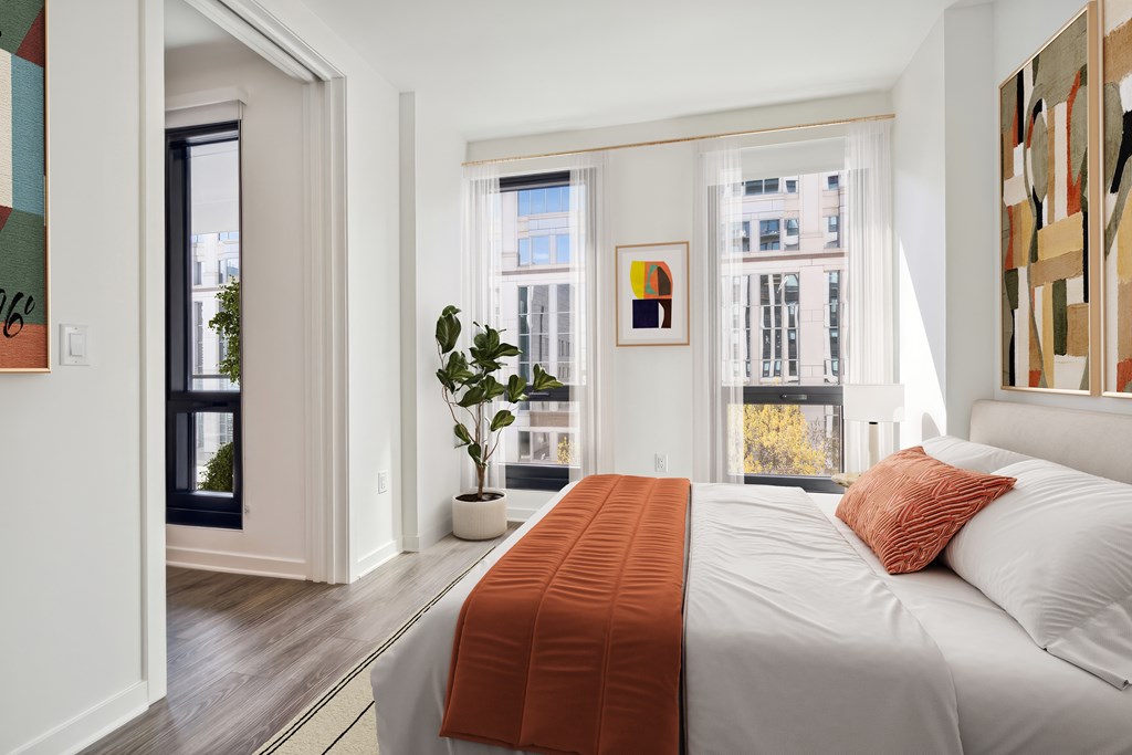 A bedroom with a large bed and a view of the city.