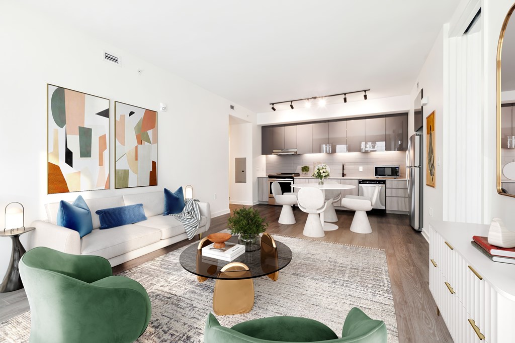 A modern living room with a white sofa, green armchair, and a coffee table.