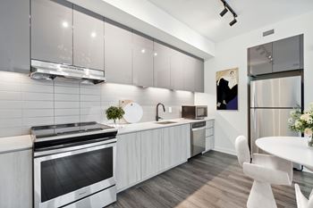 A modern kitchen with a stainless steel refrigerator and a white oven.