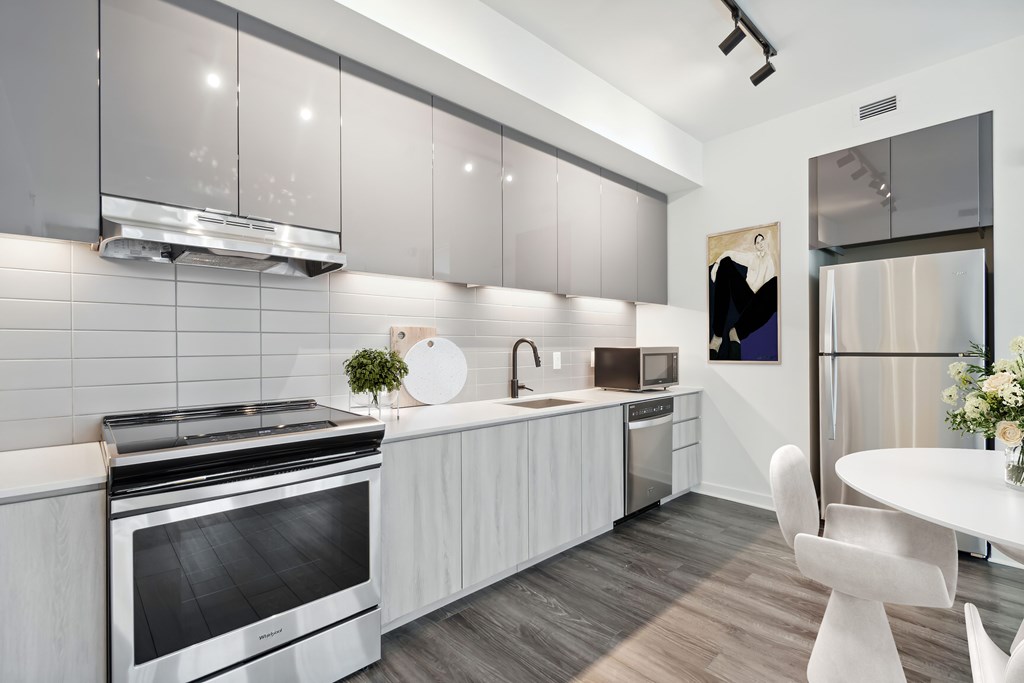 A modern kitchen with a stainless steel refrigerator and a white oven.