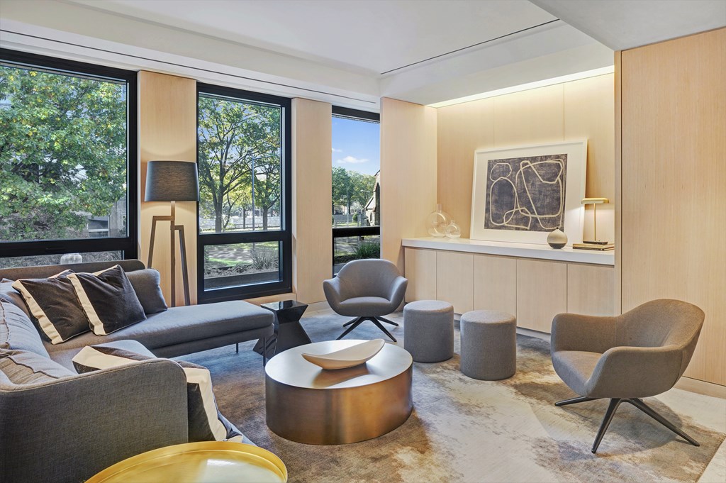 A modern living room with a grey couch, a yellow chair, and a large window.
