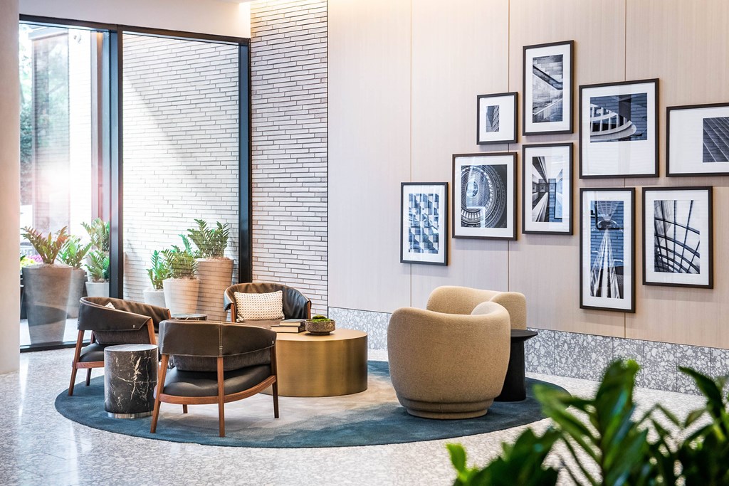 A living room with a grey and white color scheme and a large window.