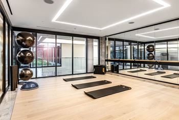 A yoga studio with wooden floors and mirrors on the wall.