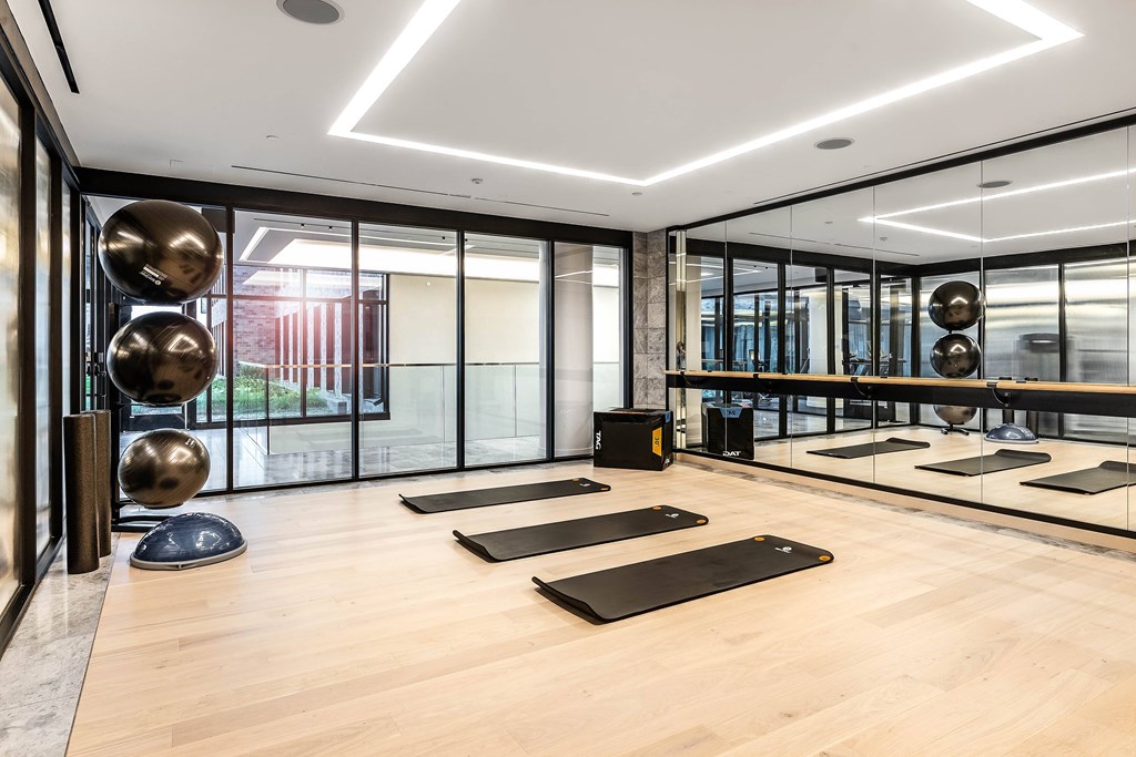 A yoga studio with wooden floors and mirrors on the wall.