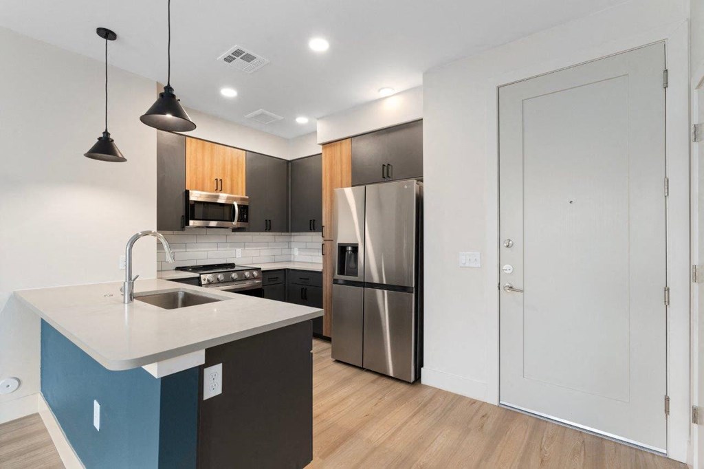 a kitchen with a stainless steel refrigerator and a sink