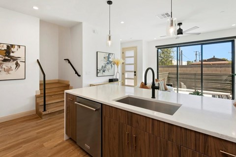 A modern kitchen with wooden cabinets and a stainless steel dishwasher.