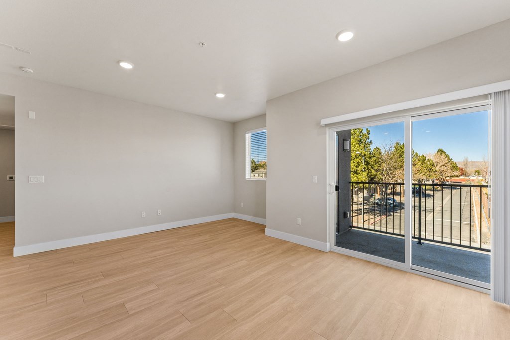 a living room with a sliding glass door to a balcony