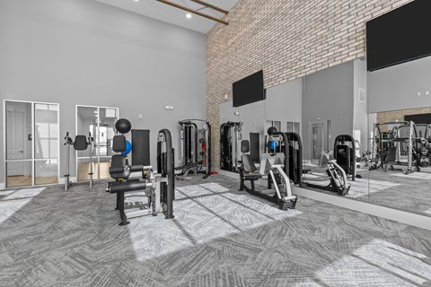 A gym with a variety of equipment including treadmills, weights, and exercise machines.