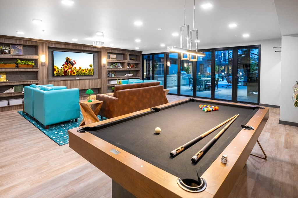 A pool table with a green felt cloth and a white ball in the foreground.