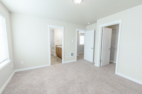 A spacious room with a carpeted floor and white walls.