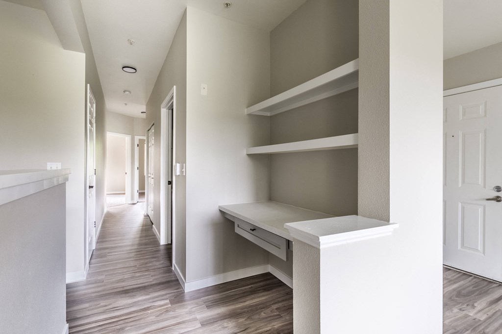 a bedroom with a desk and shelves